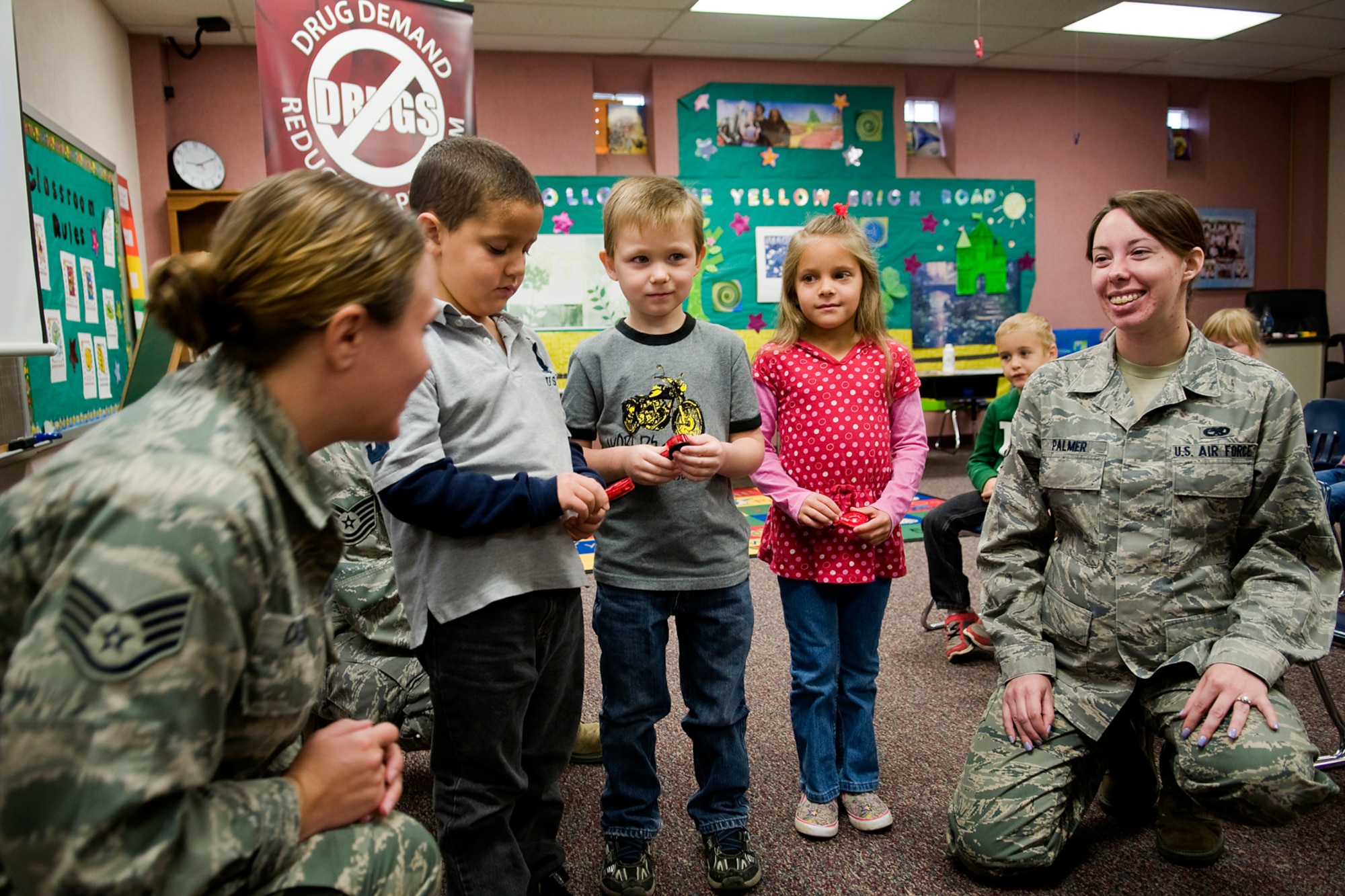 Staff Sgt. Lindsey Cassidy and Senior Airman Alina Palmer work with Elijah Burkett, Garrett Gilikison and Lauren Ramos, who are all kindergarten students, as they go through a peer-pressure exercise at Pipe Creek Elementary in Peru, Ind., Oct. 22. Cassidy is a 434th Logistics Readiness Squadron orderly room administrator and Palmer is a 434th Aircraft Maintenance Squadron KC-135 crew chief. (U.S. Air Force photo/Tech. Sgt. Mark R. W. Orders-Woempner)
