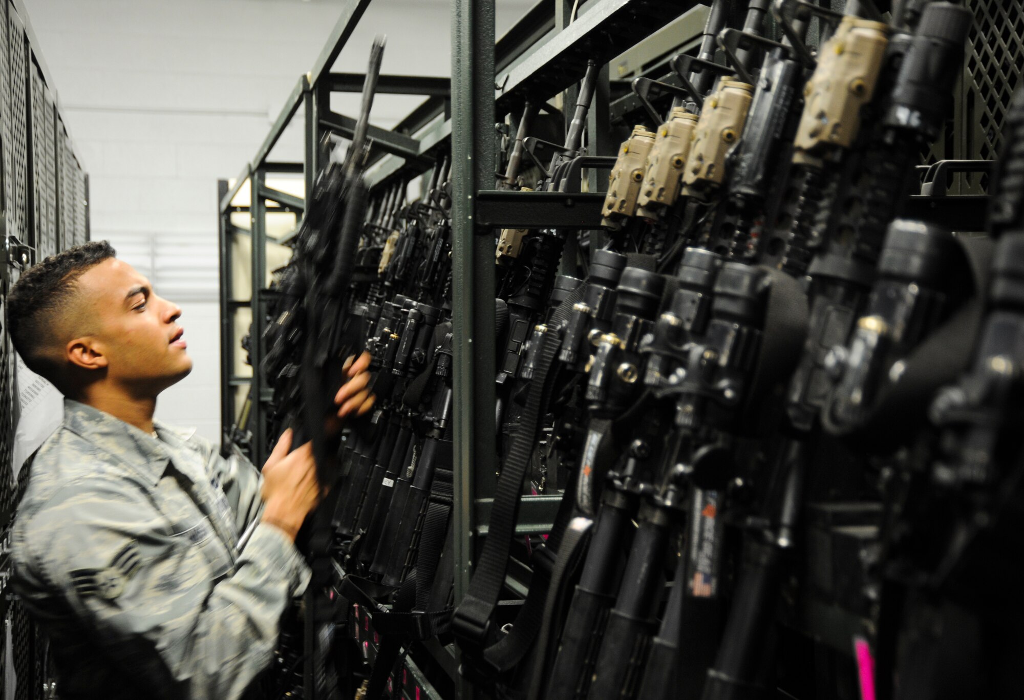 U.S. Air Force Senior Airman James Vossah, 355th Security Forces Squadron armory attendant, picks up an M-4 Carbine for issuing Davis-Monthan Air Force Base, Ariz., Oct. 23, 2013. The armory attendant issues out the required weapons and equipment to each security forces members, ensuring they have what they need to effectively carry out the mission. (U.S. Air Force photo by Senior Airman Sivan Veazie/Released)
