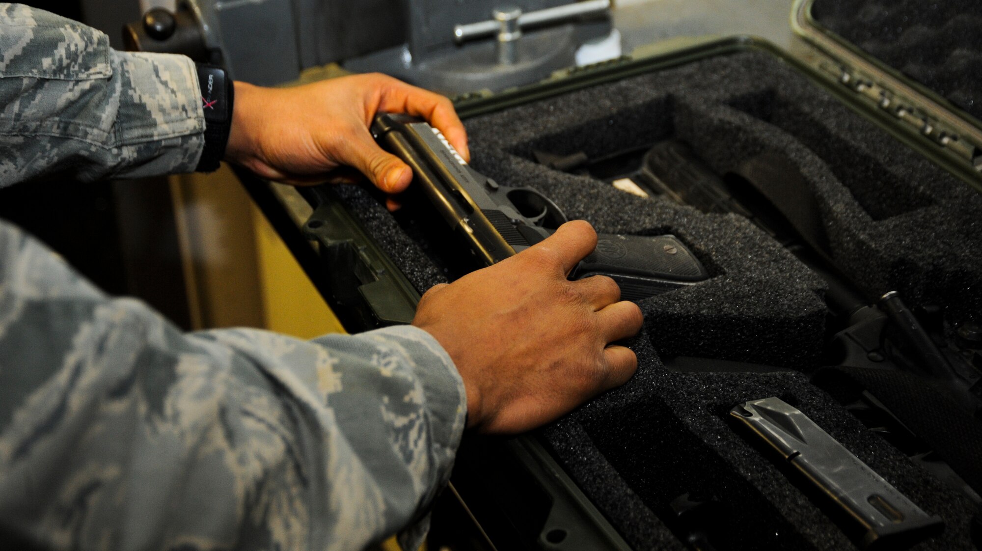 U.S. Air Force Senior Airman James Vossah, 355th Security Forces Squadron armory attendant, places an M-9 Beretta into a deployment kit at Davis-Monthan Air Force Base, Ariz., Oct. 23, 2013. Before weapons and equipment can be loaded for deployment, they must be cleaned and put through a series of inspections to ensure serviceability. (U.S. Air Force photo by Senior Airman Sivan Veazie/Released)