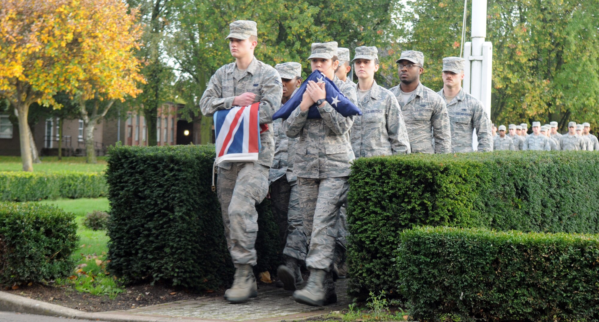 Members of the Team Mildenhall Honor Guard and Airmen Committed to Excellence retire the U.S. flag and Royal Air Force ensign during a retreat ceremony Oct. 25, 2013, on RAF Mildenhall, England.  A retreat ceremony, in which the U.S. flag and Royal Air Force ensign are retired, takes place on the last Friday of every month. A team of Airmen secured both the U.S. flag and the RAF ensign as part of the ceremony, which honors the colors and signals the official end of the duty day. (U.S. Air Force photo by Tech. Sgt. Austin May/Released)