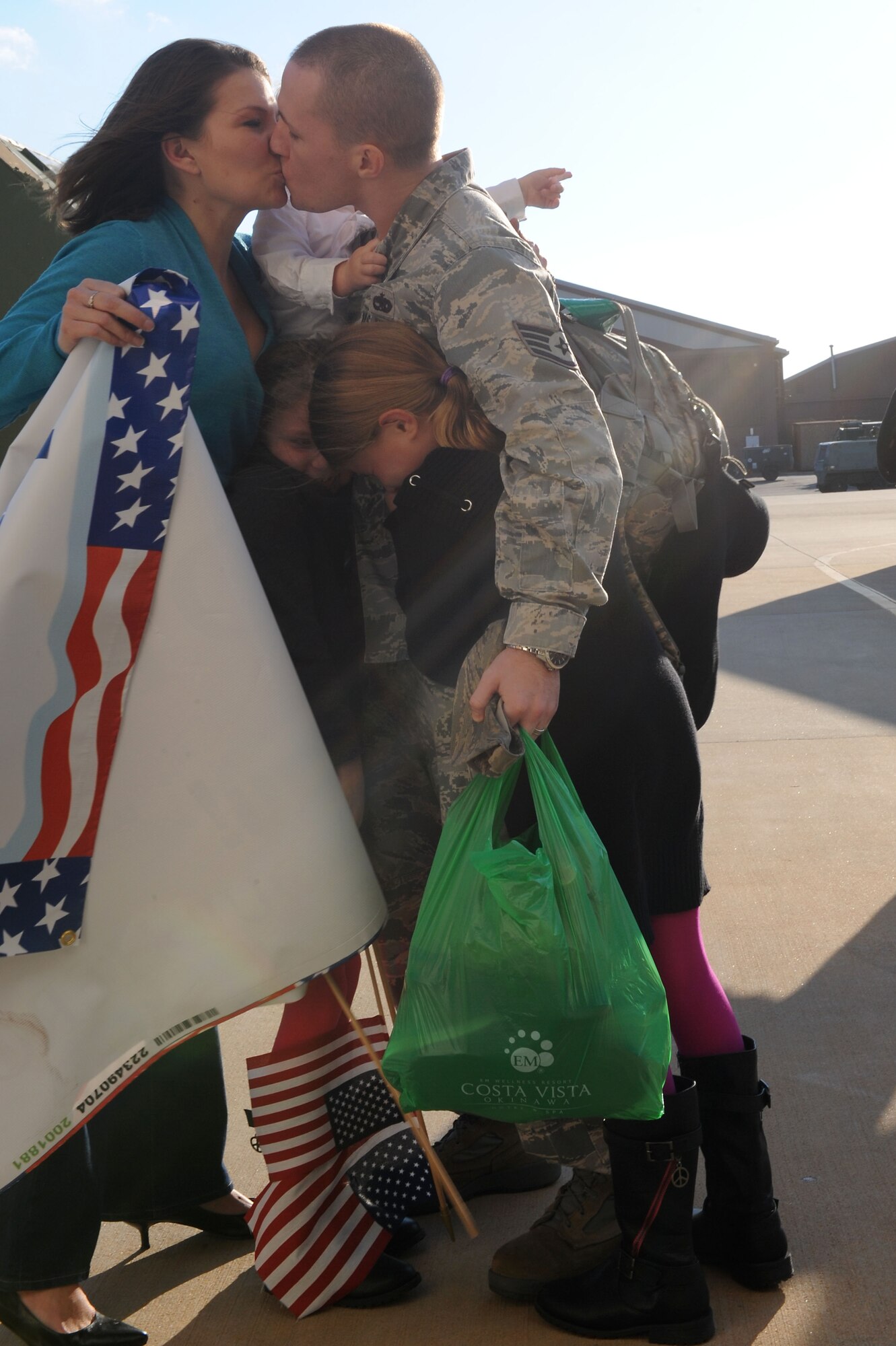 U.S. Air Force Staff Sgt. Travis Elswick, 27th Fighter Squadron munitions training manager, embraces his family at Langley Air Force Base, Va. Oct. 23, 2013, after returning from a six-month deployment. The 27th FS deployed to Kadena Air Base, Japan, in support of the Pacific Command’s Theater Security Package. (U.S. Air Force photo by Senior Airman Brittany Paerschke-O’Brien/Released)
