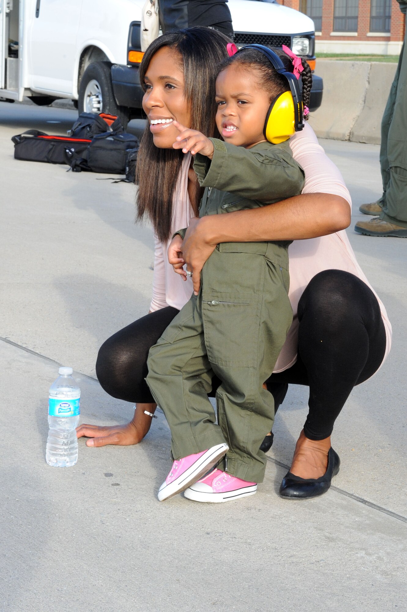 U.S. Air Force Maj. Sundonia Wonnum and her daughter Emerie watch as Maj. Jerome Wonnum, 27th Fighter Squadron assistant director of operation, returns from deployment at Langley Air Force Base, Va., Oct. 18, 2013. While on deployment, the 27th FS helped integrate with the U.S. Navy and Japanese Self Defense Force. (U.S. Air Force photo by Senior Airman Brittany Paerschke-O’Brien/Released)