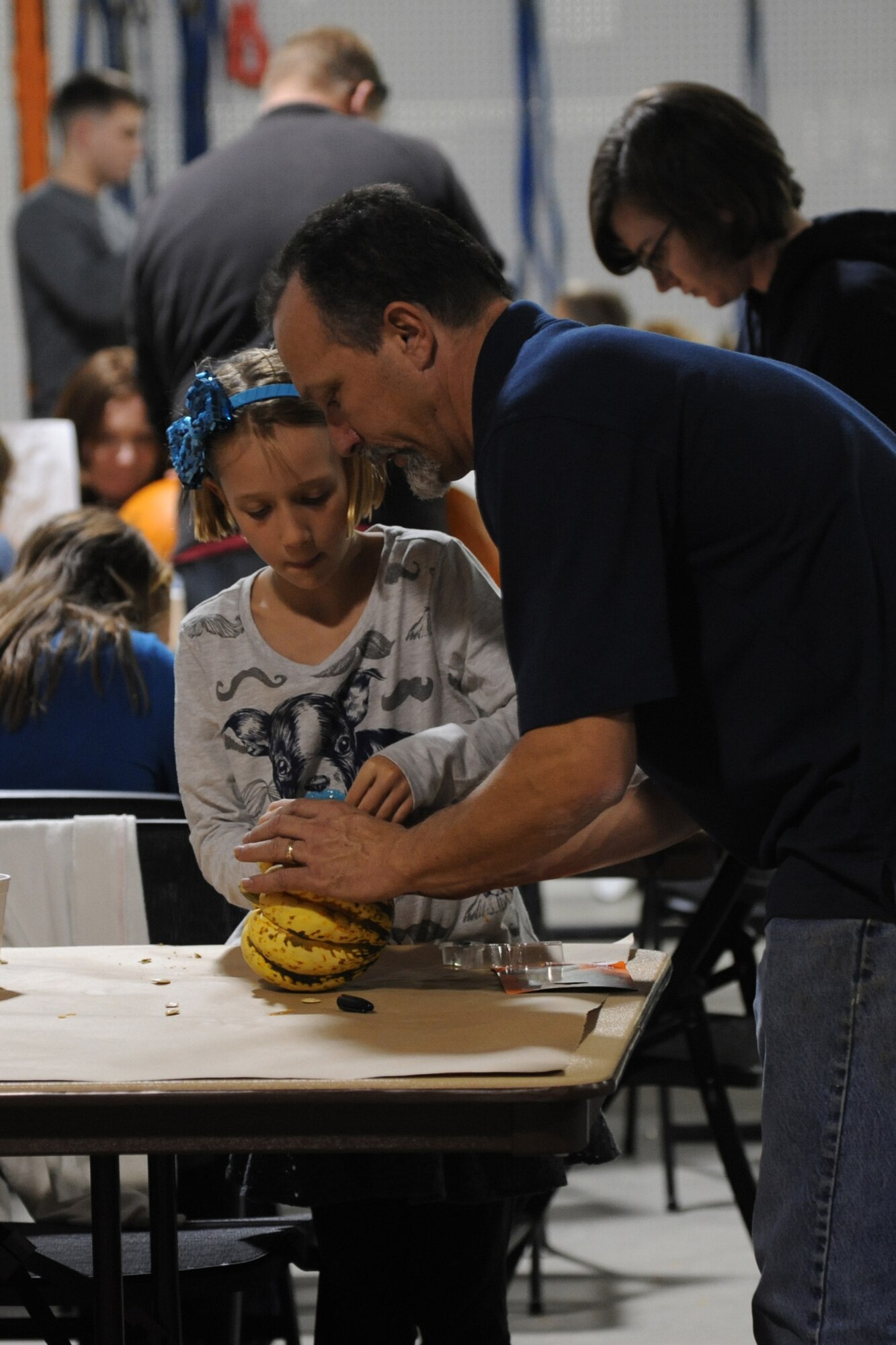 Steve Surls, 341st Force Support Squadron Outdoor Recreation Center recreation assistant, helps Chloe Piatt, 8, draw a design on a small pumpkin.  Chloe attended the pumpkin carving event with her mother, Staff Sgt. Cynthia Dial, 341st Munitions Squadron training monitor.  (U.S. Air Force photo/Senior Airman Cortney Paxton)