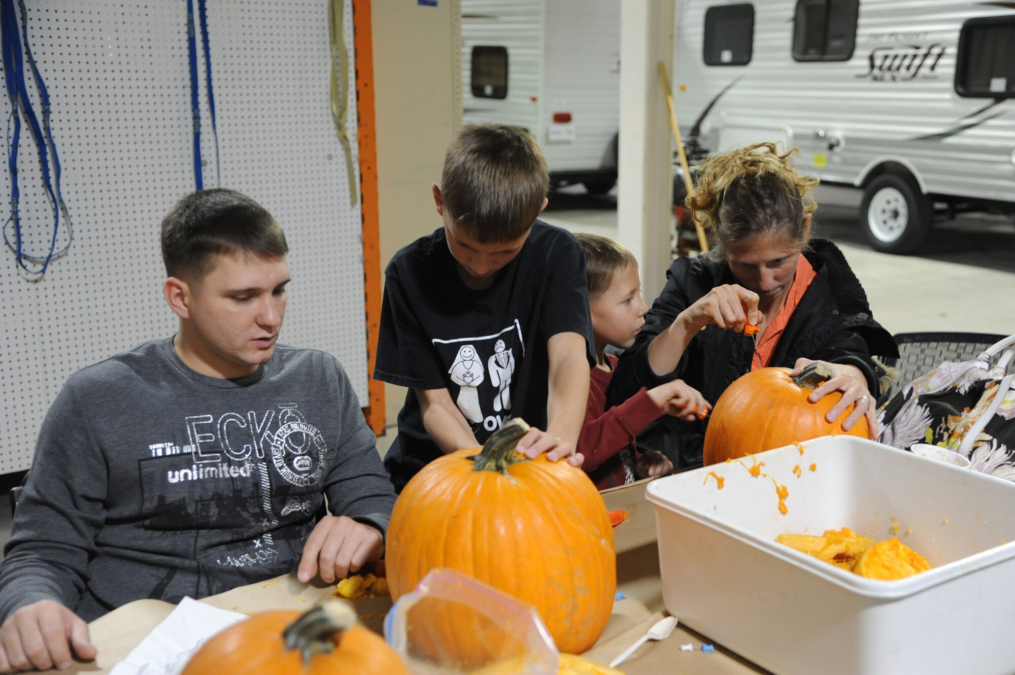 Tech. Sgt. Ron McLaughlin, 341st Missile Maintenance Squadron member; his wife, Rachel; and their sons, Christian, 10 (center left), and Brayden, 5; carve pumpkins at the Outdoor Recreation Center during a pumpkin carving event Oct. 18.  Eight families, which included more than 20 people, attended the event.  (U.S. Air Force photo/Senior Airman Cortney Paxton)
