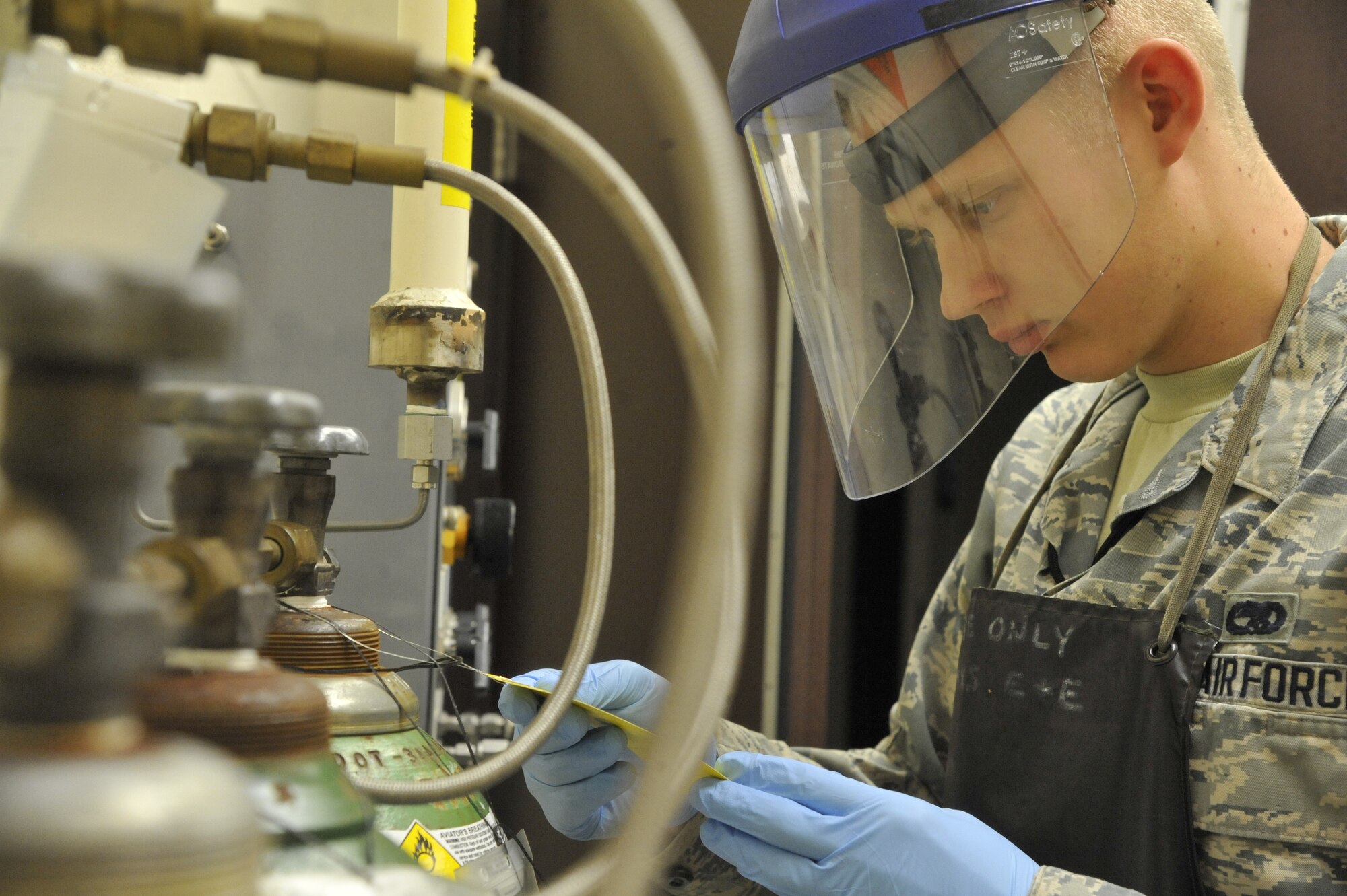U.S. Air Force Airman 1st Class Chad Grauerholz, 509th Maintenance Squadron electrical environment technician, inspects an oxygen servicing station at Whiteman Air Force Base, Mo., Oct. 15, 2013. This process is designed to ensure oxygen has not expired and there is enough pressure to fill up emergency oxygen cylinders. (U.S. Air Force photo by Airman 1st Class Keenan Berry/Released)