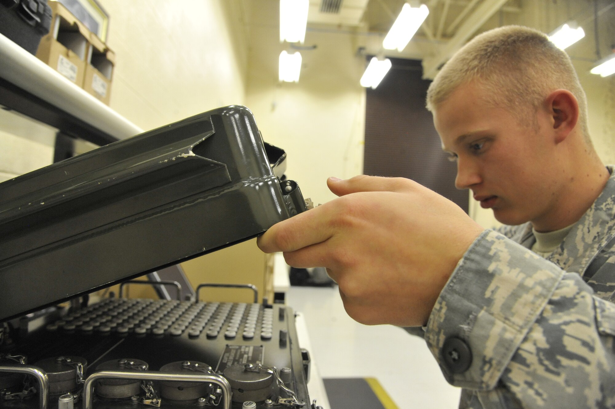 U.S. Air Force Airman 1st Class Chad Grauerholz, 509th Maintenance Squadron electrical environment technician, opens a break-out box at Whiteman Air Force Base, Mo., Oct. 15, 2013. The break-out box is used during bench checks to test line-replaceable units to make sure they function properly. (U.S. Air Force photo by Airman 1st Class Keenan Berry/Released)