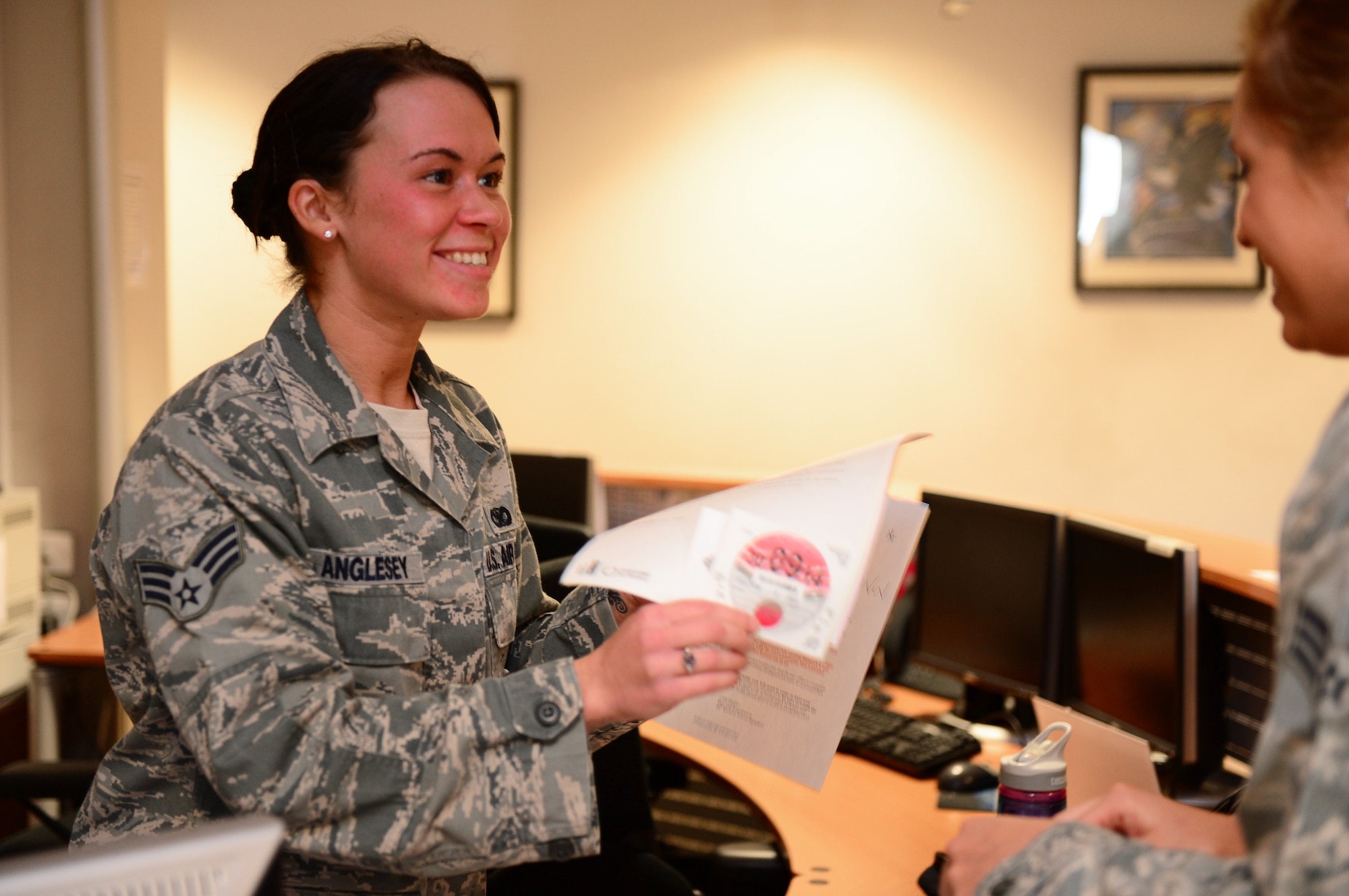 Senior Airman Chastyn Anglesey, 48th Security Forces Squadron pass and registration clerk, assists a customer at Royal Air Force Lakenheath, England, Oct. 24, 2013. Anglesey was nominated for a Liberty Spotlight because she displays the core value of Excellence in All We Do. (U.S. Air Force photo by Airman 1st Class Dawn M. Weber/Released) 