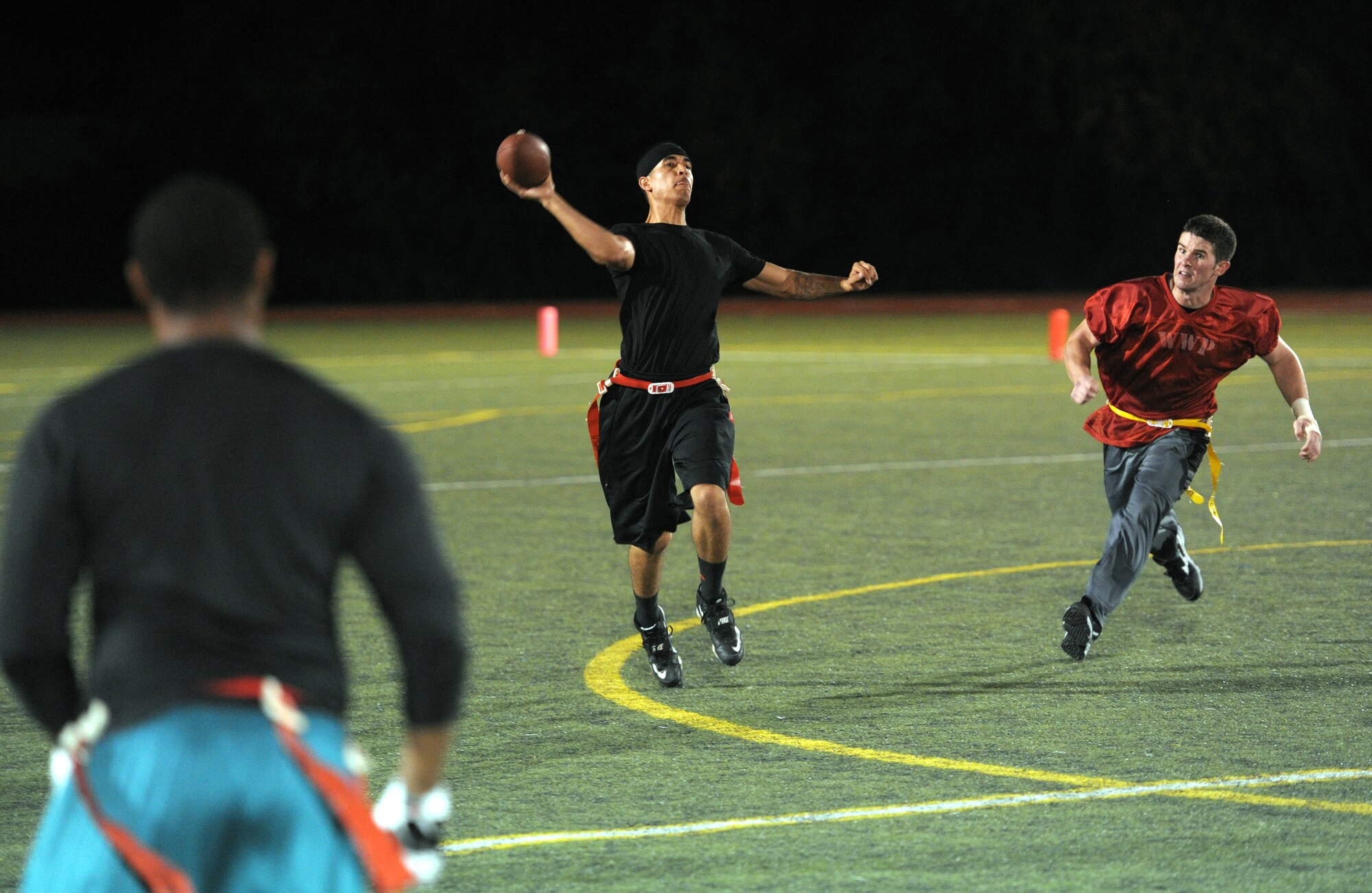 Andre Harper-Thomas, 1st Special Operations Logistics Readiness Squadron quarterback, throws the ball while rushed from his blindside by Matthew Flynn, 1st Special Operations Force Support Squadron defensive end, during the final game of the Intramural Flag Football Tournament at Hurlburt Field, Fla., Oct. 18, 2013. The LRS team tied the game, 26-26, by the end of the second half and won, 38-32, in double overtime. (U.S. Air Force photo/Senior Airman Kentavist P. Brackin)
