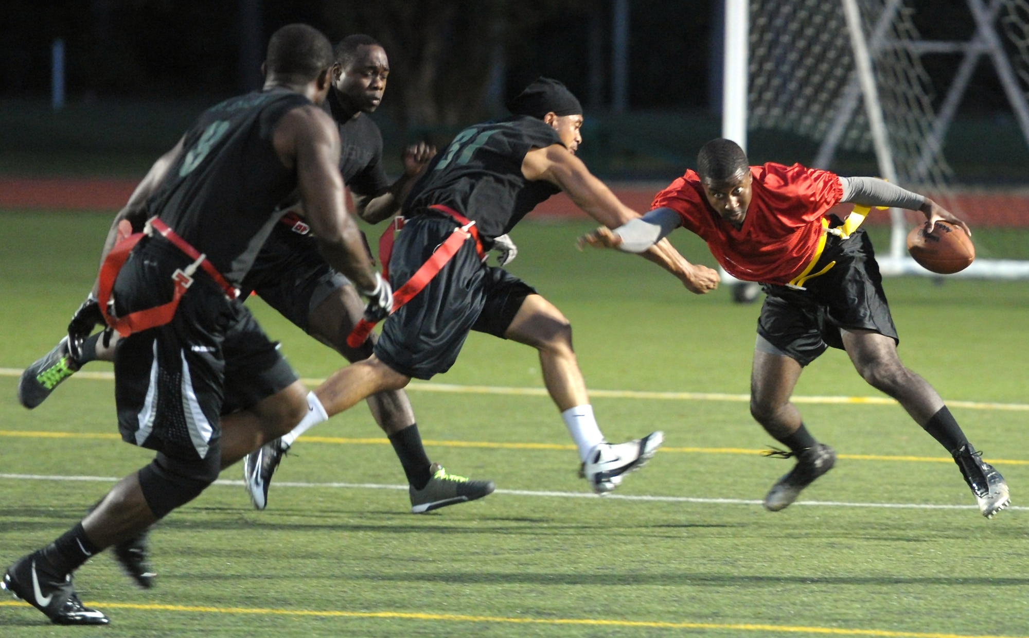 Derrick Raley, 1st Special Operations Force Support Squadron quarterback, dodges the defense during the final game of the Intramural Flag Football Tournament at Hurlburt Field, Fla., Oct. 18, 2013. Raley’s ability to rush and throw left the 1st Special Operations Logistics Readiness Squadron’s defense in disarray during the first half. (U.S. Air Force photo/Senior Airman Kentavist P. Brackin)