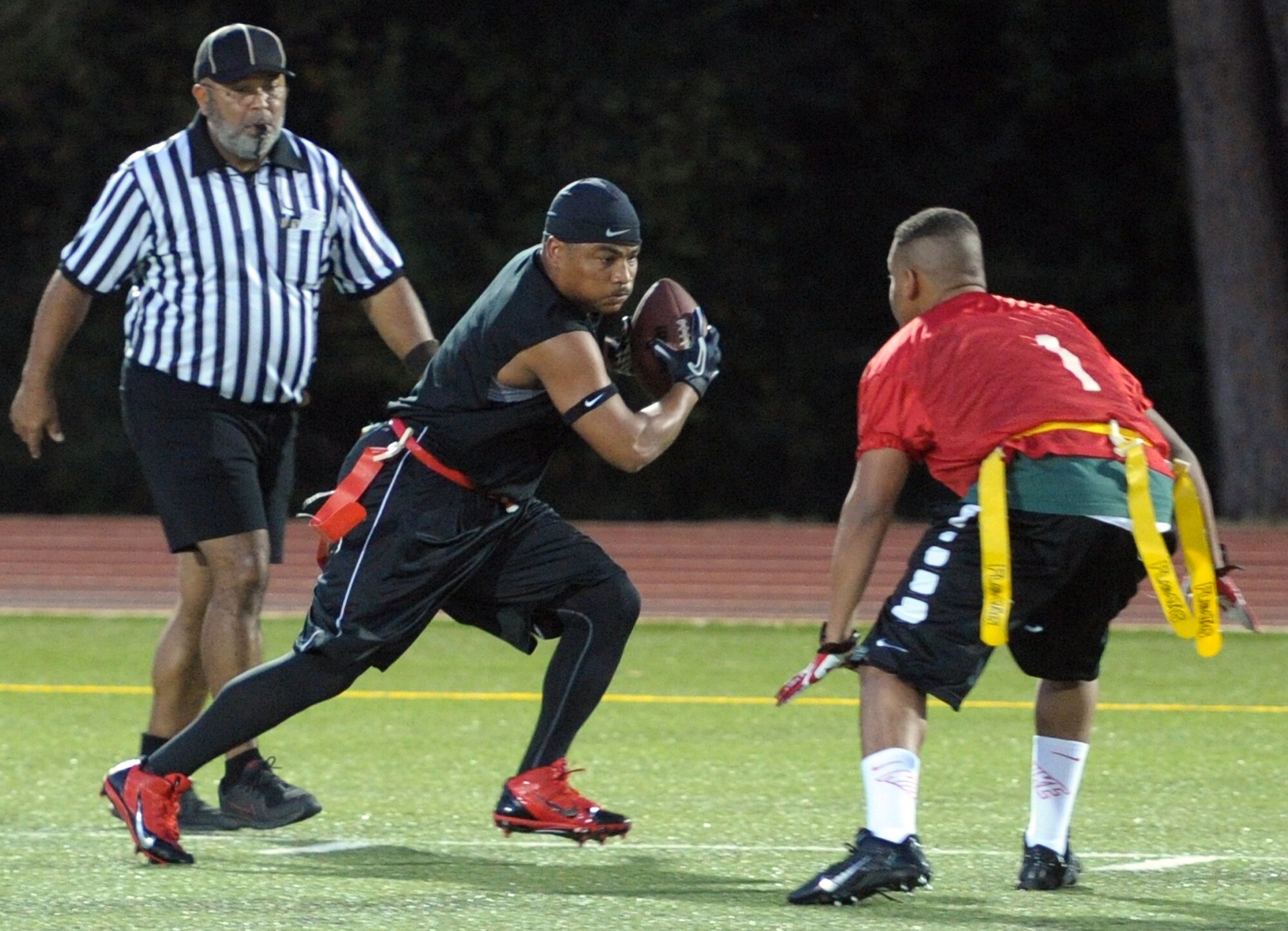 Tony Carson, 1st Special Operations Logistics Readiness Squadron, attempts to dash past Ian Duncan, 1st Special Operations Force Support Squadron defensive back, during the final game of the Intramural Flag Football Tournament at Hurlburt Field, Fla., Oct. 18, 2013. The two teams battled it out with jukes and rushes with LRS winning in double overtime, 38-32. (U.S. Air Force photo/Senior Airman Kentavist P. Brackin)
