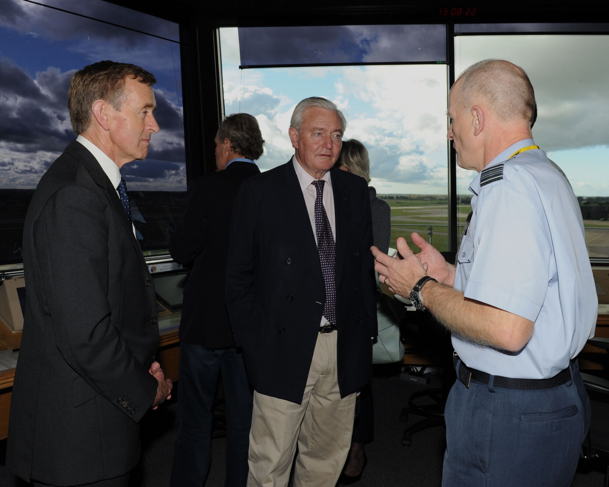 Royal Air Force Sqn. Ldr. Richard Fryer, right, RAF Mildenhall station commander, speaks with Lord Edward Leicester, center, husband of Lady Sarah Leicester, High Sheriff of Norfolk, and Sir Edward Greenwell, High Sheriff of Suffolk, Oct. 23, 2013, in the air traffic control tower on RAF Mildenhall, England. Local high sheriffs toured the base to learn more about its mission and how it affects the local community. (U.S. Air Force photo by Airman 1st Class Preston Webb/Released)