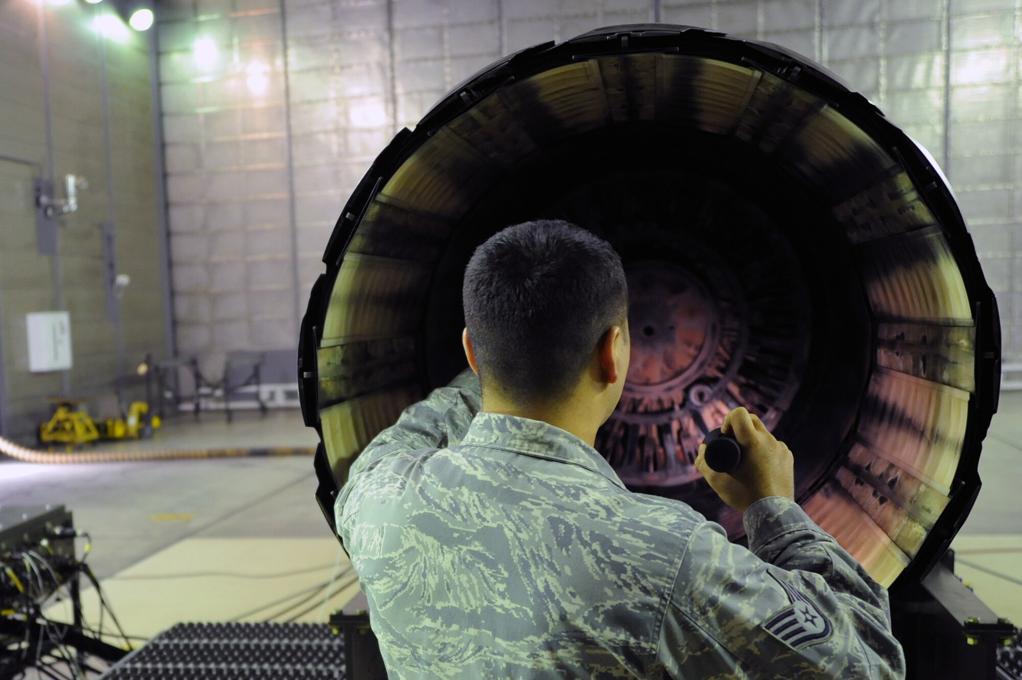 U.S. Air Force Staff Sgt. Mitchell Morelos, 35th Maintenance Squadron test cell craftsman, inspects an F110-GE-129 engine used on an F-16 Fighting Falcon before performing various tests at Misawa Air Base, Japan, Oct. 23, 2013. Morelos is part of the aerospace propulsion section, and has been testing engines used on F-16s for three years. (U.S. Air Force photo by Senior Airman Derek VanHorn)