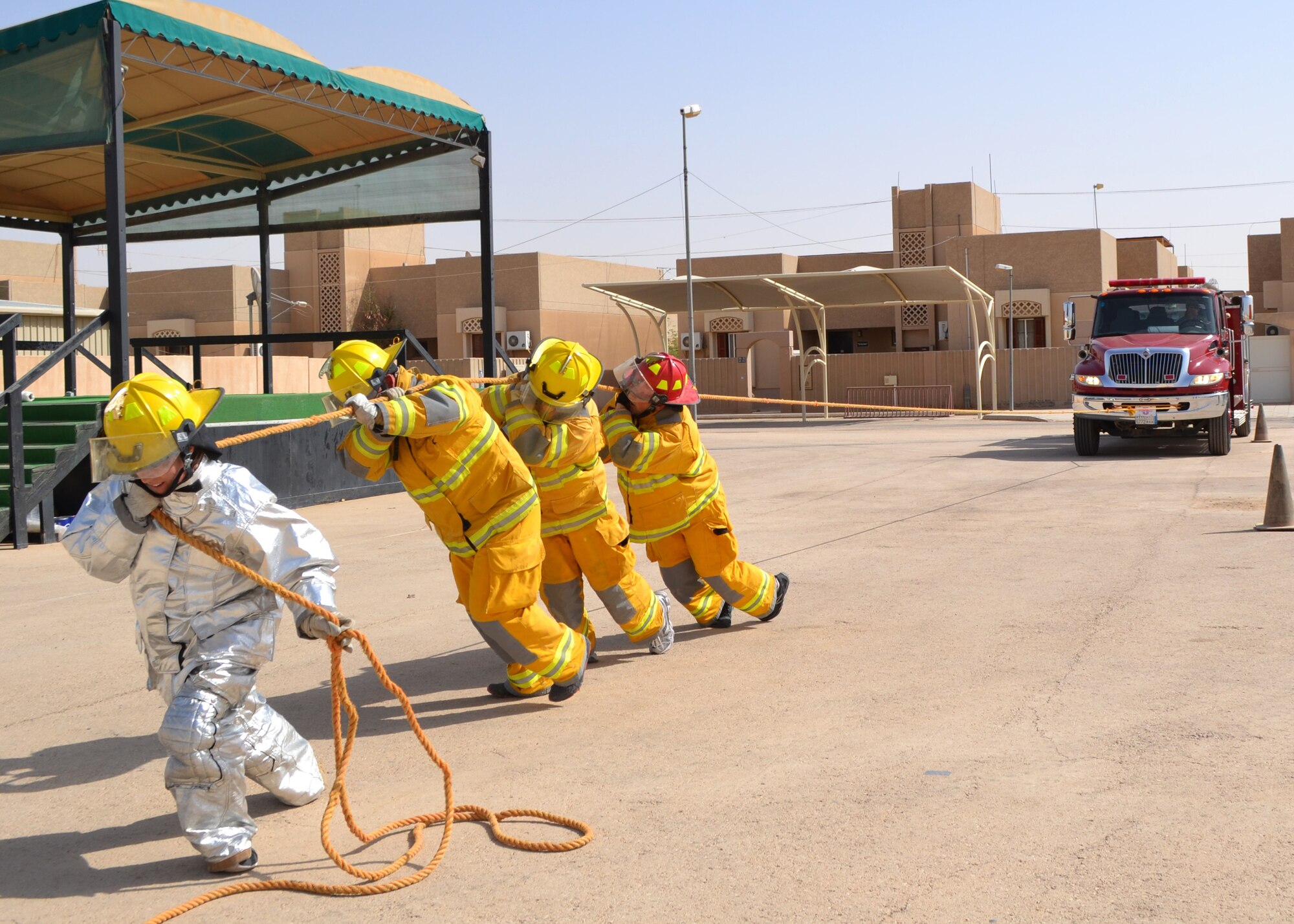 Members of the 64th Expeditionary Support Squadron pull a fire truck during a firefighter challenge at the 64th Air Expeditionary Group in Southwest Asia, Oct. 11, 2013. The challenge was a timed team completion, which included everything from donning the bunker gear to pulling a 45,000-pound tanker truck. (Courtesy photo) 

