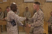 Sgt. Maj. Paul Archie (left), the guest of honor at the Corporals Course graduation for Combat Logistics Regiment 2, Regional Command (Southwest), presents a graduating certificate to Cpl. Lee Walls, a Port St. Lucie, Fla., native, during a ceremony at Camp Leatherneck, Afghanistan, Oct. 11, 2013. Walls received the "Gung Ho" award for his outstanding attitude and performance during the course.
