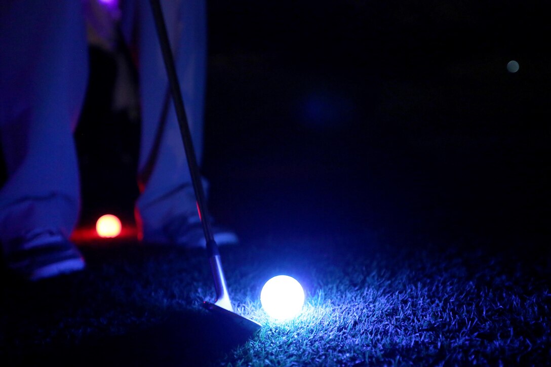 Lance Cpl. Travis Wendt lines up his wedge during the Glow-Ball tournament at the Marine Memorial Golf Course Oct. 25. The par three course was nine holes, dimly lit by neon lights at each hole and the lighted necklaces the participants wore. Wendt is a middle-eastern cryptologic linguist with 1st Radio Battalion, 1st Marine Expeditionary Force.