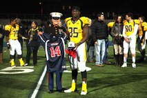 SSgt. Alex Renner, a Recruiter with Recruiting Station St. Louis, presents a Semper Fidelis All-American Bowl jersey to high school senior Dewayne Hendrix during a football game in O'Fallon, Ill., Oct. 25, 2013. Hendrix was selected to participate in the Semper Fidelis All-American Bowl in January in Carson, Calif. Hendrix plays Defensive End on the O'Fallon Township High School varsity football team and is ranked a four-star recruit and 189th in the ESPN top 300. He has had 22 scholarship offers, but has yet to commit. (Official U.S. Marine Photo by Cpl. Erik S. Brooks Jr.)