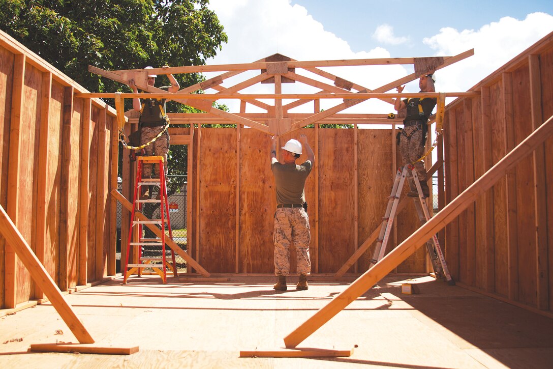 Marines with Combat Logistics Battalion 3 lift a truss into place while building a Southwestern Asia hut at engineer building lot 4079, Oct. 10.