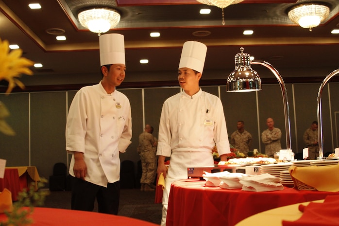 Mori Nobu, left, Club Iwakuni sous chef, walks with another chef as they check food preparation before serving it at a reception for Col. James C. Stewart, former station commanding officer, in the Club Iwakuni ballroom at Marine Corps Air Station Iwakuni, Japan, July 12, 2013. Nobu has 13 years of experience at Club Iwakuni and is second-in-command of the kitchen.