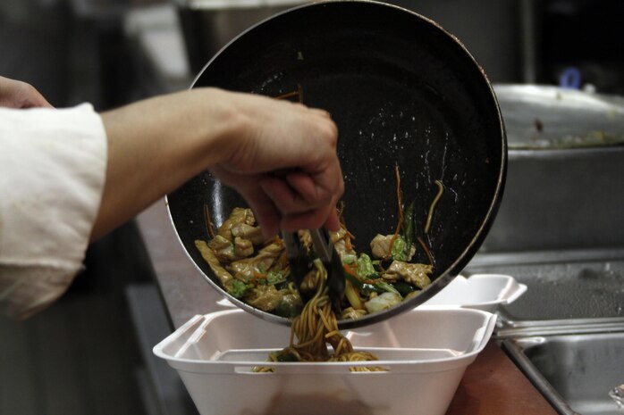 Yasunobu Asaeda, Club Iwakuni supervisor, completes chicken stir-fry while the other chefs complete orders for a busy breakfast rush at Club Iwakuni at Marine Corps Air Station Iwakuni, Japan, July 20, 2013. Before working at Club Iwakuni, Asaeda worked at the Crossoads Mall food court and the Landing Zone diner as well.