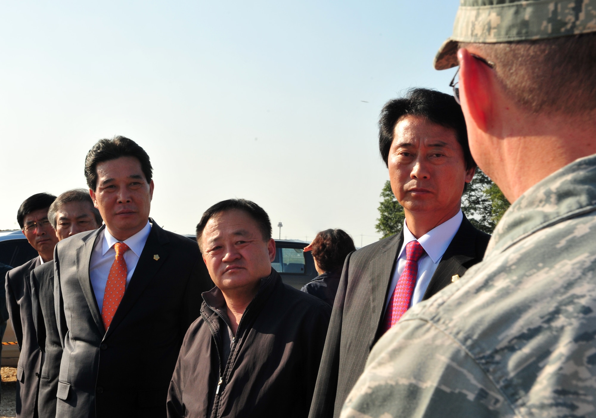 Soong-ho Kim, left, Pyeongtaek City Council member, Seung-keun Lim, Pyeongtaek City Council vice chairman, and Gi-Sung Kim, Pyeongtaek City Council member, discuss the second runway construction site with Col. Michael Strunk, 51st Mission Support Group commander, at Osan Air Base, Republic of Korea, Oct. 18, 2013. Strunk emphasized the care being taken to identify and safely remove any contaminated material found at the site, as well as the efforts being made to recycle any safe re-usable materials. (U.S. Air Force photo/Airman 1st Class Ashley J. Thum)