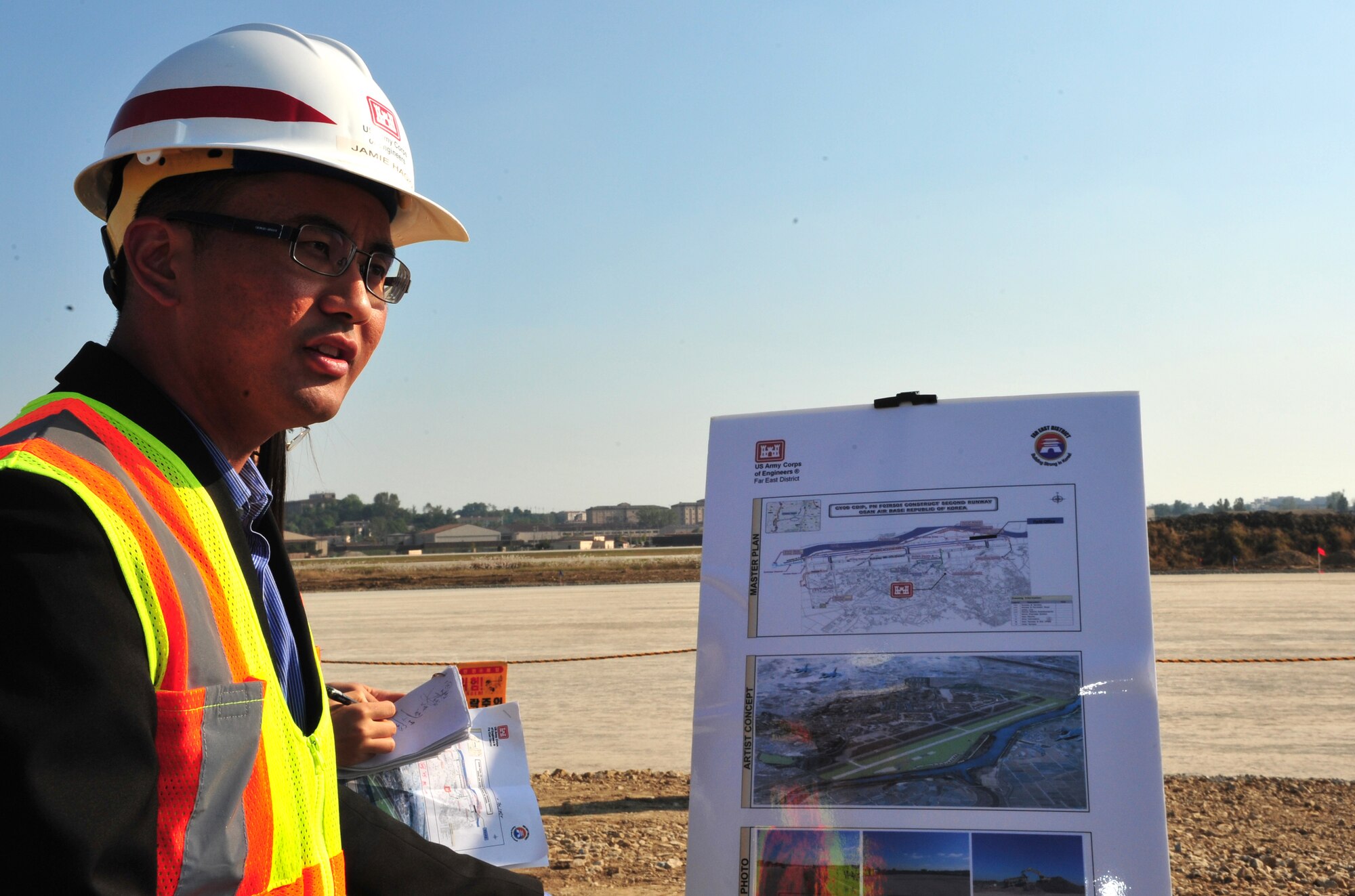 Jamie Hagio, U.S. Army Corps of Engineers resident engineer for the 51st Civil Engineer Squadron, briefs members of Pyeongtaek leadership about the second runway construction site at Osan Air Base, Republic of Korea, Oct. 18, 2013. The presentation was part of a tour of the construction site and debris sorting area to assuage environmental protection concerns among the city council. (U.S. Air Force photo/Airman 1st Class Ashley J. Thum)