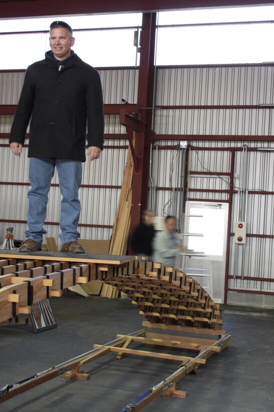 Sgt. Maj. Steven Brown, Marine Corps Air Station Iwakuni sergeant major, stands on the finished replica of a Kintai Bridge arch at Sekido Storage Warehouse, Dec. 7, 2012. Patrons learned about the architecture of the bridge and applied the knowledge toward working together and completing the replica.