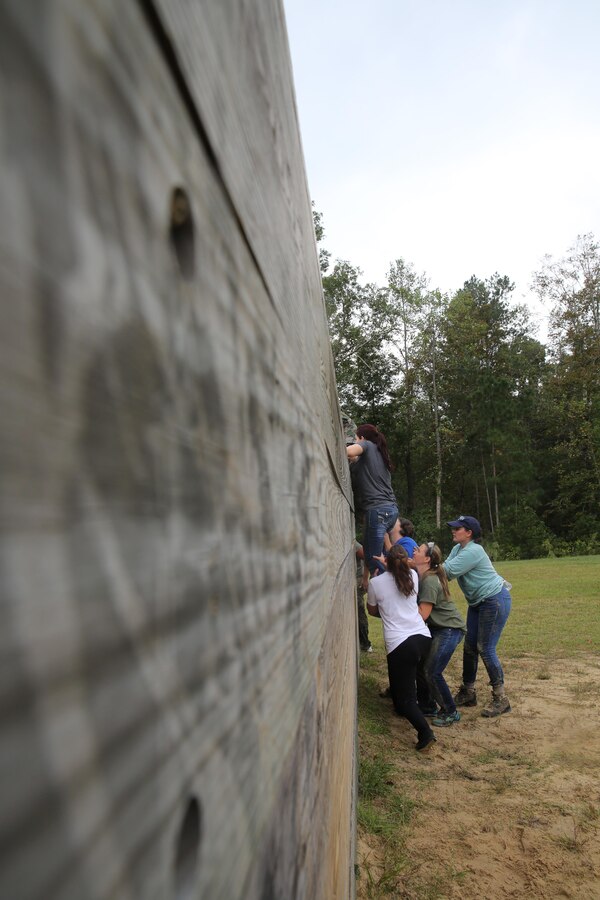 Participants of a Jane Wayne Day event run through an obstacle course on Camp Lejeune, N.C., Oct. 19, 2013.  The event was organized by Marine Special Operations Regiment, allowing wives of MARSOC personnel to experience firsthand how Critical Skills Operators train for missions.  This Jane Wayne Day event immersed participants in an interactive scenario comprising patrols, a run through an obstacle course, rides on zodiac boats, encounters with role-players and a simulated raid on a town.  MARSOC Marines supervised the entire event, and assisted the family members throughout the scenario.(U.S. Marine Corps Photo by Lance Cpl. Steven Fox/Released)