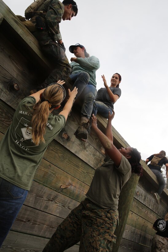 Participants of a Jane Wayne Day event run through an obstacle course on Camp Lejeune, N.C., Oct. 19, 2013.  The event was organized by Marine Special Operations Regiment, allowing wives of MARSOC personnel to experience firsthand how Critical Skills Operators train for missions.  This Jane Wayne Day event immersed participants in an interactive scenario comprising patrols, a run through an obstacle course, rides on zodiac boats, encounters with role-players and a simulated raid on a town.  MARSOC Marines supervised the entire event, and assisted the family members throughout the scenario. (U.S. Marine Corps Photo by Lance Cpl. Steven Fox/Released)