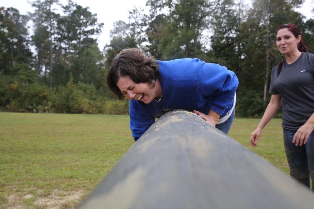 Participants of a Jane Wayne Day event run through an obstacle course on Camp Lejeune, N.C., Oct. 19, 2013.  The event was organized by Marine Special Operations Regiment, allowing wives of MARSOC personnel to experience firsthand how Critical Skills Operators train for missions.  This Jane Wayne Day event immersed participants in an interactive scenario comprising patrols, a run through an obstacle course, rides on zodiac boats, encounters with role-players and a simulated raid on a town.  MARSOC Marines supervised the entire event, and assisted the family members throughout the scenario. (U.S. Marine Corps Photo by Lance Cpl. Steven Fox/Released)