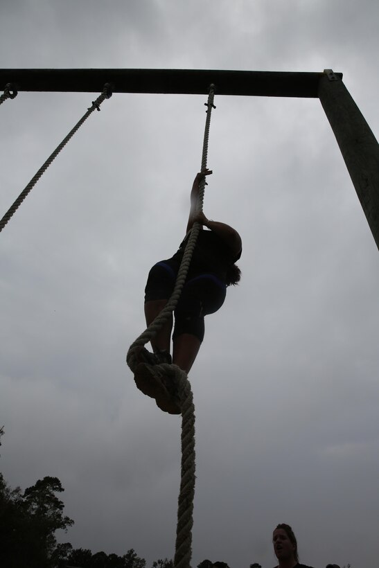 Participants of a Jane Wayne Day event run through an obstacle course on Camp Lejeune, N.C., Oct. 19, 2013.  The event was organized by Marine Special Operations Regiment, allowing wives of MARSOC personnel to experience firsthand how Critical Skills Operators train for missions.  This Jane Wayne Day event immersed participants in an interactive scenario comprising patrols, a run through an obstacle course, rides on zodiac boats, encounters with role-players and a simulated raid on a town.  MARSOC Marines supervised the entire event, and assisted the family members throughout the scenario. (U.S. Marine Corps Photo by Lance Cpl. Steven Fox/Released)