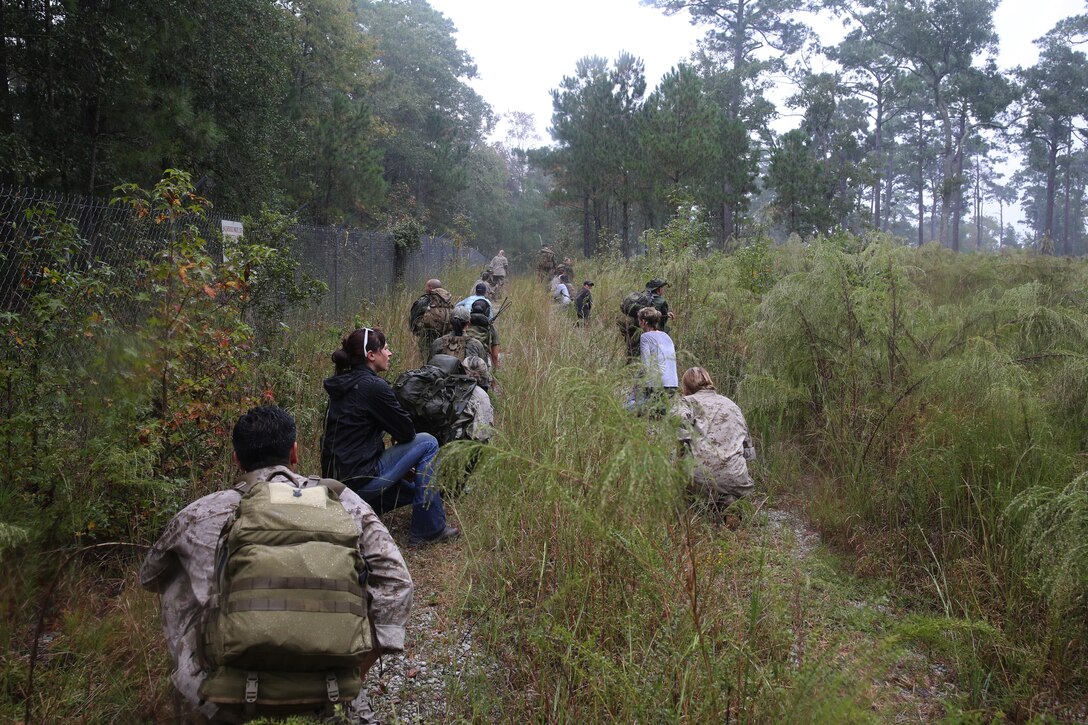 Participants of a Jane Wayne Day event patrol in a tactical formation on Camp Lejeune, N.C., Oct 19, 2013.  The event was organized by Marine Special Operations Regiment, allowing wives of MARSOC personnel to experience firsthand how Critical Skills Operators train for missions.  This Jane Wayne Day event immersed participants in an interactive scenario comprising patrols, a run through an obstacle course, rides on zodiac boats, encounters with role-players and a simulated raid on a town. MARSOC Marines supervised the entire event, and assisted the family members throughout the scenario.(U.S. Marine Corps Photo by Lance Cpl. Steven Fox/Released)