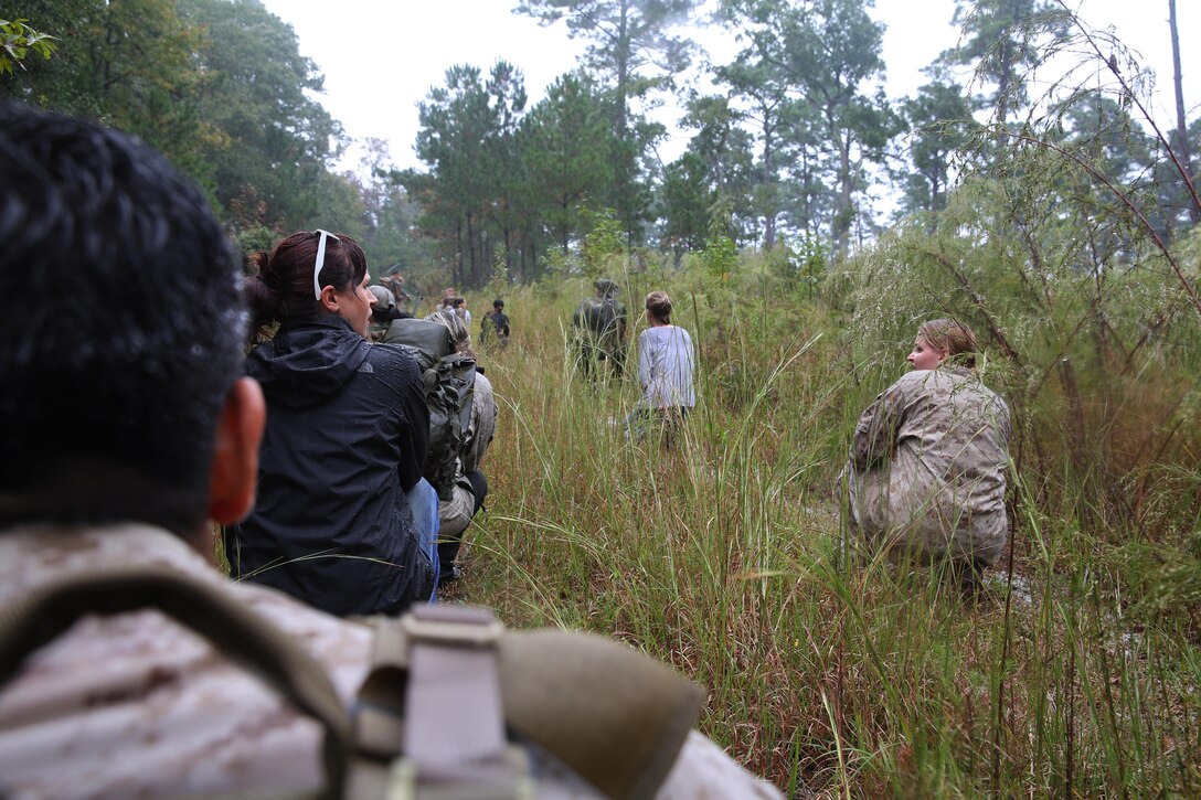 Participants of a Jane Wayne Day event patrol in a tactical formation on Camp Lejeune, N.C., Oct 19, 2013.  The event was organized by Marine Special Operations Regiment, allowing wives of MARSOC personnel to experience firsthand how Critical Skills Operators train for missions.  This Jane Wayne Day event immersed participants in an interactive scenario comprising patrols, a run through an obstacle course, rides on zodiac boats, encounters with role-players and a simulated raid on a town.  MARSOC Marines supervised the entire event, and assisted the family members throughout the scenario. (U.S. Marine Corps Photo by Lance Cpl. Steven Fox/Released)