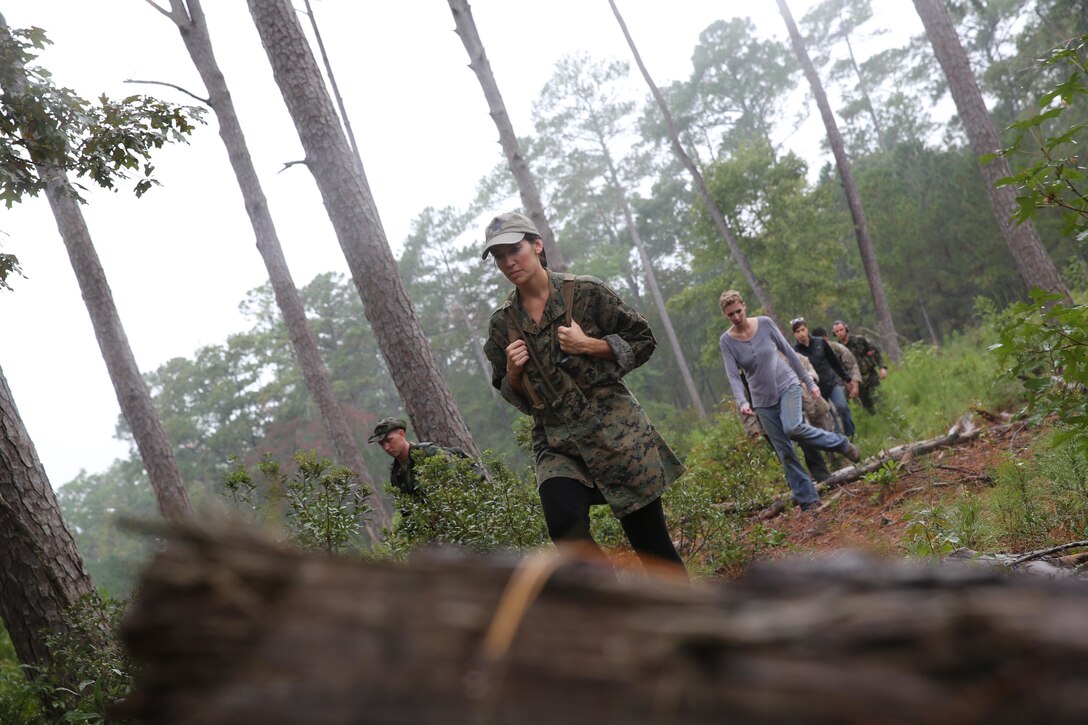 Participants of a Jane Wayne Day event patrol in a tactical formation on Camp Lejeune, N.C., Oct. 19, 2013.  The event was organized by Marine Special Operations Regiment, allowing wives of MARSOC personnel to experience firsthand how Critical Skills Operators train for missions.  This Jane Wayne Day event immersed participants in an interactive scenario comprising patrols, a run through an obstacle course, rides on zodiac boats, encounters with role-players and a simulated raid on a town.  MARSOC Marines supervised the entire event, and assisted the family members throughout the scenario. (U.S. Marine Corps Photo by Lance Cpl. Steven Fox/Released)