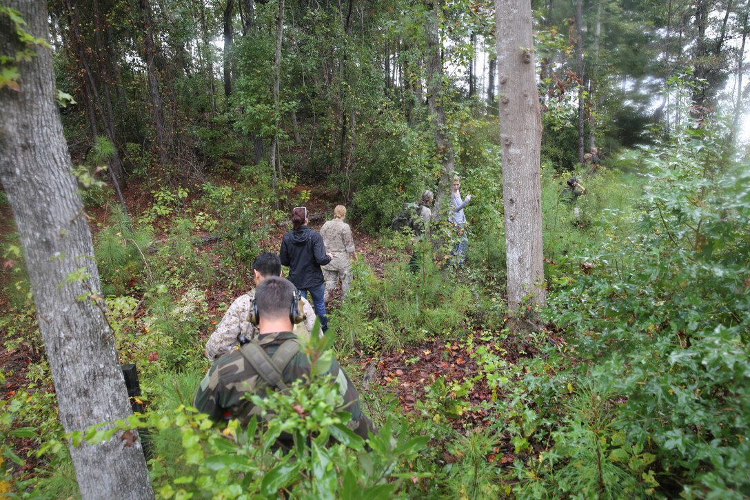 Participants of a Jane Wayne Day event patrol through vegetation on Camp Lejeune, N.C., Oct. 19, 2013.  The event was organized by Marine Special Operations Regiment, allowing wives of MARSOC personnel to experience firsthand how Critical Skills Operators train for missions.  This Jane Wayne Day event immersed participants in an interactive scenario comprising patrols, a run through an obstacle course, rides on zodiac boats, encounters with role-players and a simulated raid on a town.  MARSOC Marines supervised the entire event, and assisted the family members throughout the scenario. (U.S. Marine Corps Photo by Lance Cpl. Steven Fox/Released)