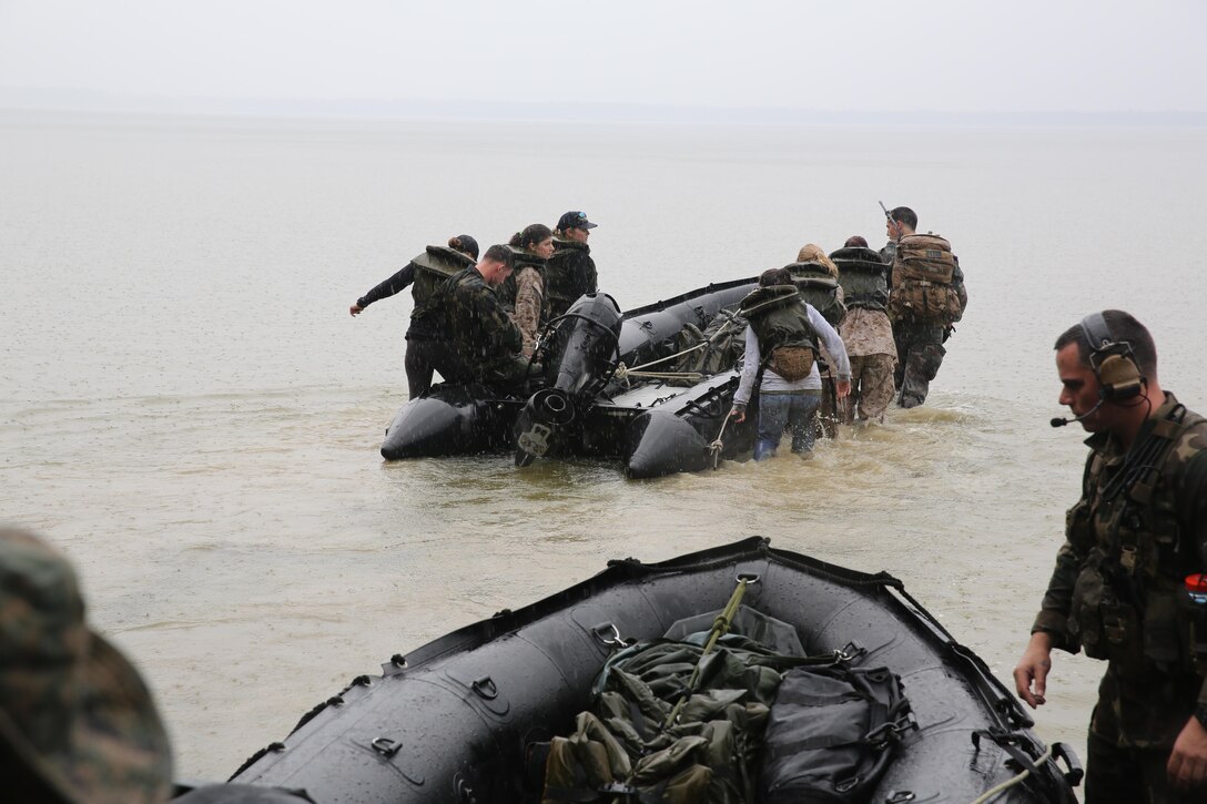 Marines with U.S. Marine Corps Forces, Special Operations Command prepare to transport participants of a Jane Wayne Day event to a location on Camp Lejeune, N.C., via zodiac boats, Oct. 19, 2013.  The event was organized by Marine Special Operations Regiment, allowing wives of MARSOC personnel to experience firsthand how Critical Skills Operators train for missions.  This Jane Wayne Day event immersed participants in an interactive scenario comprising patrols, a run through an obstacle course, rides on zodiac boats, encounters with role-players and a simulated raid on a town.  MARSOC Marines supervised the entire event, and assisted the family members throughout the scenario. (U.S. Marine Corps Photo by Lance Cpl. Steven Fox/Released)