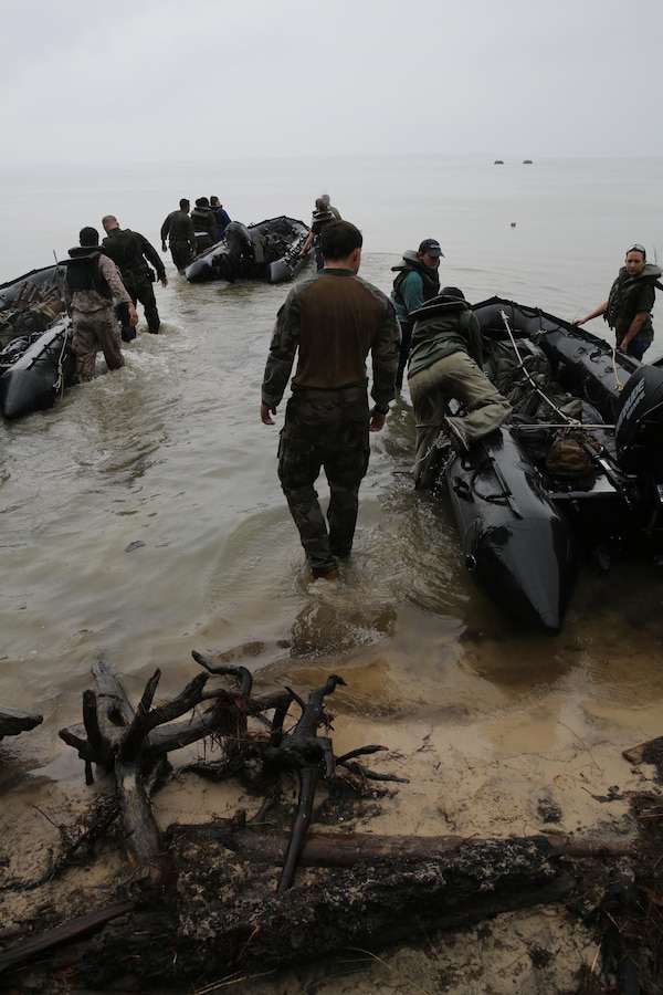 Marines with U.S. Marine Corps Forces, Special Operations Command prepare to transport participants of a Jane Wayne Day event to a location on Camp Lejeune, N.C., via zodiac boats, Oct. 19, 2013.  The event was organized by Marine Special Operations Regiment, allowing wives of MARSOC personnel to experience firsthand how Critical Skills Operators train for missions.  This Jane Wayne Day event immersed participants in an interactive scenario comprising patrols, a run through an obstacle course, rides on zodiac boats, encounters with role-players and a simulated raid on a town.  MARSOC Marines supervised the entire event, and assisted the family members throughout the scenario. (U.S. Marine Corps Photo by Lance Cpl. Steven Fox/Released)