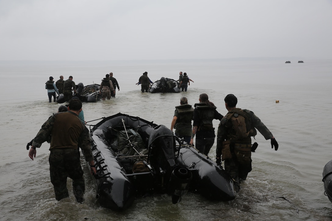 Marines with U.S. Marine Corps Forces, Special Operations Command prepare to transport participants of a Jane Wayne Day event to a location on Camp Lejeune, N.C., via zodiac boats, Oct. 19, 2013.  The event was organized by Marine Special Operations Regiment, allowing wives of MARSOC personnel to experience firsthand how Critical Skills Operators train for missions.  This Jane Wayne Day event immersed participants in an interactive scenario comprising patrols, a run through an obstacle course, rides on zodiac boats, encounters with role-players and a simulated raid on a town.  MARSOC Marines supervised the entire event, and assisted the family members throughout the scenario. (U.S. Marine Corps Photo by Lance Cpl. Steven Fox/Released)