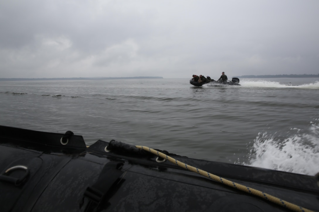 Participants of a Jane Wayne Day event hang on tight as they are transported to a location on Camp Lejeune, N.C., via zodiac boats, Oct. 19, 2013.  The event was organized by Marine Special Operations Regiment, allowing wives of MARSOC personnel to experience firsthand how Critical Skills Operators train for missions.  This Jane Wayne Day event immersed participants in an interactive scenario comprising patrols, a run through an obstacle course, rides on zodiac boats, encounters with role-players and a simulated raid on a town.  MARSOC Marines supervised the entire event, and assisted the family members throughout the scenario. (U.S. Marine Corps Photo by Lance Cpl. Steven Fox/Released)