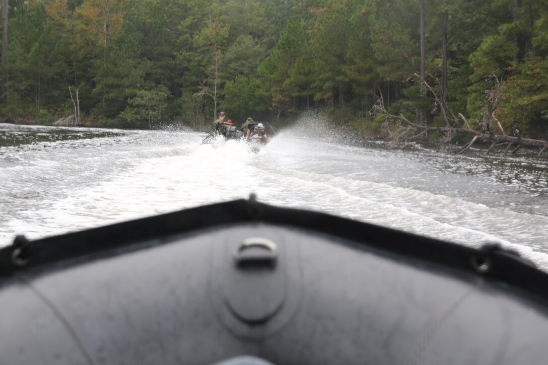 Participants of a Jane Wayne Day event hang on tight as they are transported to a location on Camp Lejeune, N.C., via zodiac boats, Oct. 19, 2013.  The event was organized by Marine Special Operations Regiment, allowing wives of MARSOC personnel to experience firsthand how Critical Skills Operators train for missions.  This Jane Wayne Day event immersed participants in an interactive scenario comprising patrols, a run through an obstacle course, rides on zodiac boats, encounters with role-players and a simulated raid on a town.  MARSOC Marines supervised the entire event, and assisted the family members throughout the scenario. (U.S. Marine Corps Photo by Lance Cpl. Steven Fox/Released)