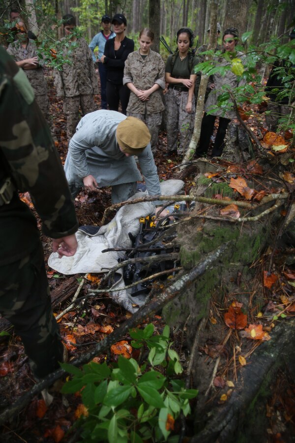 Participants of a Jane Wayne Day event encounter a role player during a simulated special operations mission on Camp Lejeune, N.C., Oct. 19, 2013.  The event was organized by Marine Special Operations Regiment, allowing wives of MARSOC personnel to experience firsthand how Critical Skills Operators train for missions.  This Jane Wayne Day event immersed participants in an interactive scenario comprising patrols, a run through an obstacle course, rides on zodiac boats, encounters with role-players and a simulated raid on a town.  MARSOC Marines supervised the entire event, and assisted the family members throughout the scenario. (U.S. Marine Corps Photo by Lance Cpl. Steven Fox/Released)