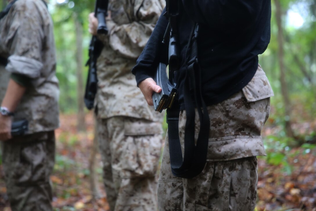 Participants of a Jane Wayne Day event encounter a role player during a simulated special operations mission on Camp Lejeune, N.C., Oct. 19, 2013.  The event was organized by Marine Special Operations Regiment, allowing wives of MARSOC personnel to experience firsthand how Critical Skills Operators train for missions.  This Jane Wayne Day event immersed participants in an interactive scenario comprising patrols, a run through an obstacle course, rides on zodiac boats, encounters with role-players and a simulated raid on a town.  MARSOC Marines supervised the entire event, and assisted the family members throughout the scenario. (U.S. Marine Corps Photo by Lance Cpl. Steven Fox/Released)