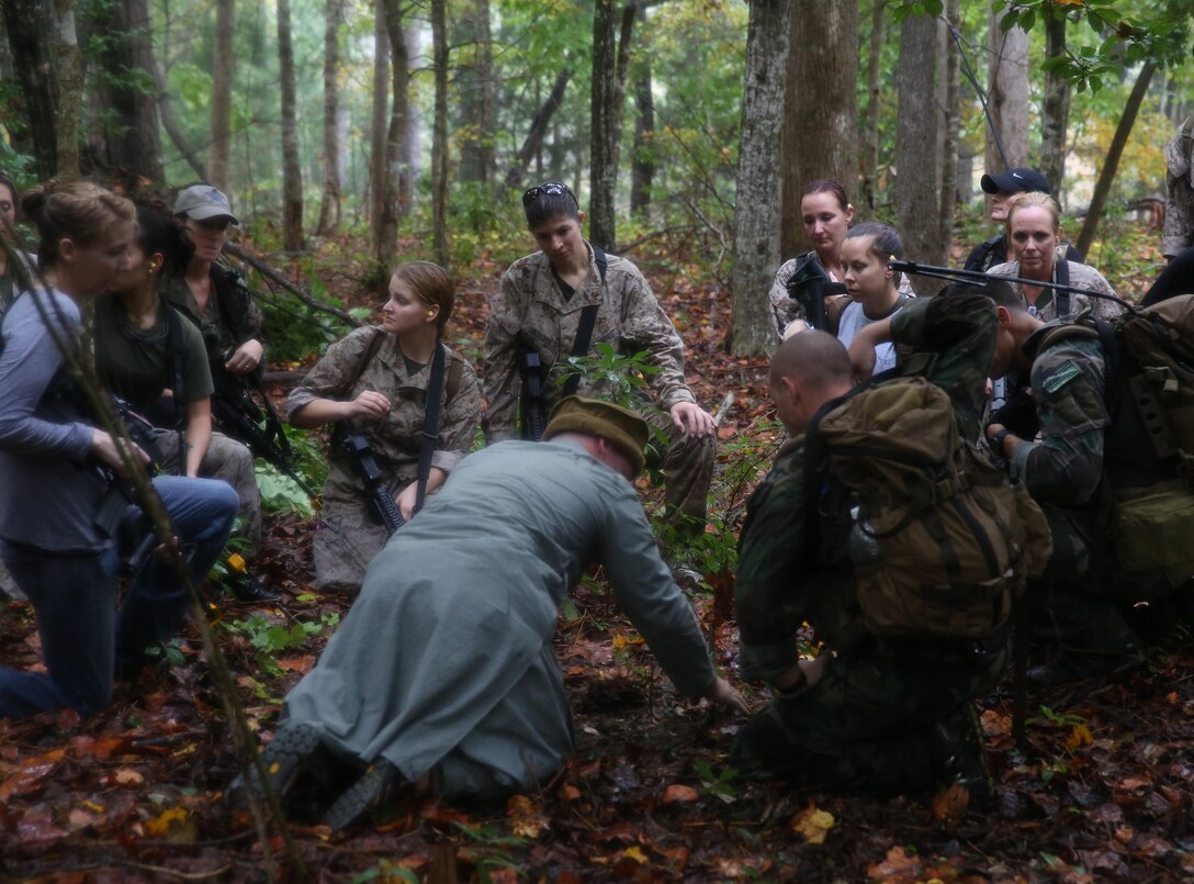 Participants of a Jane Wayne Day event encounter a role player during a simulated special operations mission on Camp Lejeune, N.C., Oct. 19, 2013.  The event was organized by Marine Special Operations Regiment, allowing wives of MARSOC personnel to experience firsthand how Critical Skills Operators train for missions.  This Jane Wayne Day event immersed participants in an interactive scenario comprising patrols, a run through an obstacle course, rides on zodiac boats, encounters with role-players and a simulated raid on a town.  MARSOC Marines supervised the entire event, and assisted the family members throughout the scenario. (U.S. Marine Corps Photo by Lance Cpl. Steven Fox/Released)