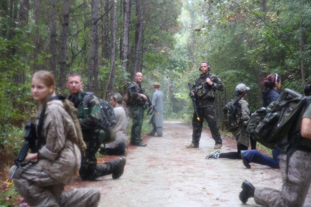 Participants of a Jane Wayne Day event patrol in a tactical formation as they advance to the location of a simulated raid on a town at Camp Lejeune, N.C., Oct. 19, 2013.  The event was organized by Marine Special Operations Regiment, allowing wives of MARSOC personnel to experience firsthand how Critical Skills Operators train for missions.  This Jane Wayne Day event immersed participants in an interactive scenario comprising patrols, a run through an obstacle course, rides on zodiac boats, encounters with role-players and a simulated raid on a town.  MARSOC Marines supervised the entire event, and assisted the family members throughout the scenario. (U.S. Marine Corps Photo by Lance Cpl. Steven Fox/Released)