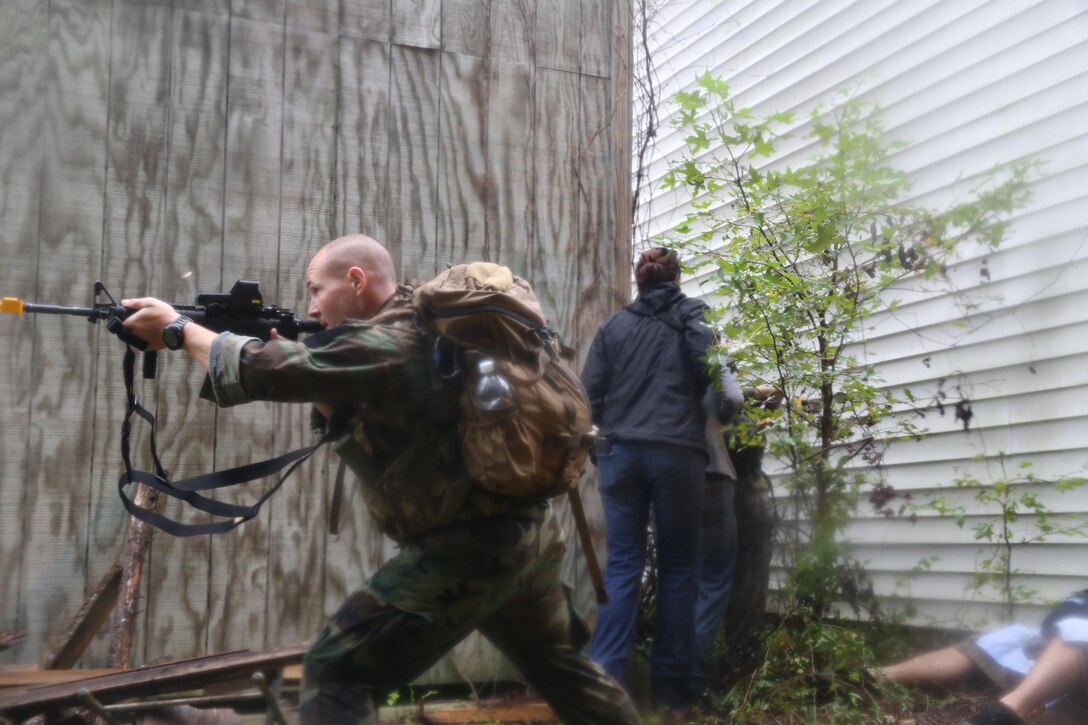 Participants of a Jane Wayne Day event raid a town during the last portion of a simulated special operations mission on Camp Lejeune, N.C., Oct. 19, 2013.  The event was organized by Marine Special Operations Regiment, allowing wives of MARSOC personnel to experience firsthand how Critical Skills Operators train for missions.  This Jane Wayne Day event immersed participants in an interactive scenario comprising patrols, a run through an obstacle course, rides on zodiac boats, encounters with role-players and a simulated raid on a town.  MARSOC Marines supervised the entire event, and assisted the family members throughout the scenario. (U.S. Marine Corps Photo by Lance Cpl. Steven Fox/Released)