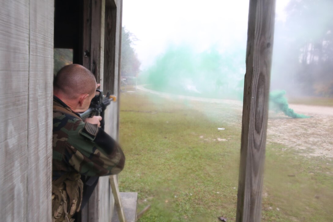 Participants of a Jane Wayne Day event raid a town during the last portion of a simulated special operations mission on Camp Lejeune, N.C., Oct. 19, 2013.  The event was organized by Marine Special Operations Regiment, allowing wives of MARSOC personnel to experience firsthand how Critical Skills Operators train for missions.  This Jane Wayne Day event immersed participants in an interactive scenario comprising patrols, a run through an obstacle course, rides on zodiac boats, encounters with role-players and a simulated raid on a town.  MARSOC Marines supervised the entire event, and assisted the family members throughout the scenario. (U.S. Marine Corps Photo by Lance Cpl. Steven Fox/Released)