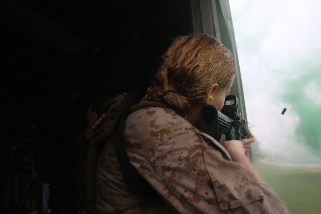 Participants of a Jane Wayne Day event raid a town during the last portion of a simulated special operations mission on Camp Lejeune, N.C., Oct. 19, 2013.  The event was organized by Marine Special Operations Regiment, allowing wives of MARSOC personnel to experience firsthand how Critical Skills Operators train for missions.  This Jane Wayne Day event immersed participants in an interactive scenario comprising patrols, a run through an obstacle course, rides on zodiac boats, encounters with role-players and a simulated raid on a town.  MARSOC Marines supervised the entire event, and assisted the family members throughout the scenario. (U.S. Marine Corps Photo by Lance Cpl. Steven Fox/Released)