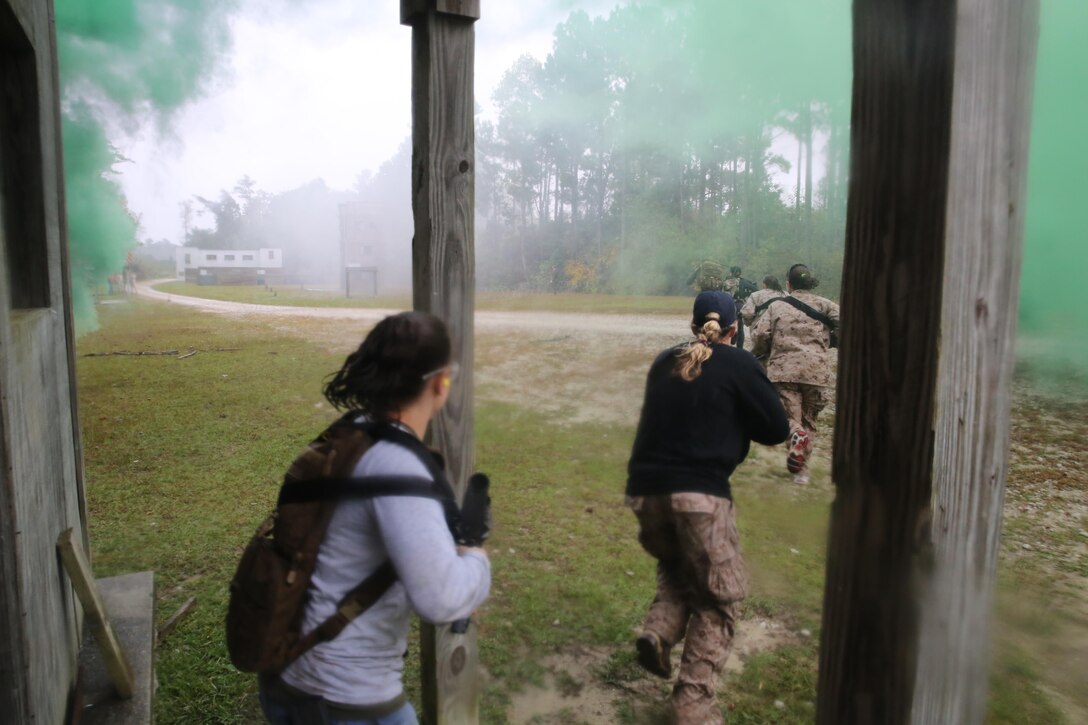 Participants of a Jane Wayne Day event raid a town during the last portion of a simulated special operations mission on Camp Lejeune, N.C., Oct. 19, 2013.  The event was organized by Marine Special Operations Regiment, allowing wives of MARSOC personnel to experience firsthand how Critical Skills Operators train for missions.  This Jane Wayne Day event immersed participants in an interactive scenario comprising patrols, a run through an obstacle course, rides on zodiac boats, encounters with role-players and a simulated raid on a town.  MARSOC Marines supervised the entire event, and assisted the family members throughout the scenario. (U.S. Marine Corps Photo by Lance Cpl. Steven Fox/Released)