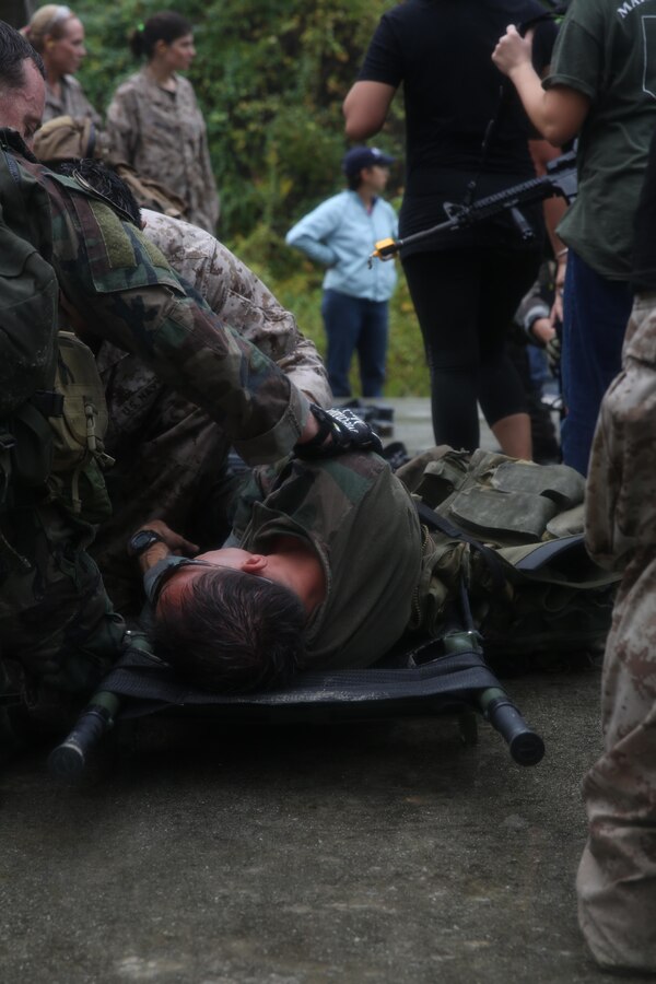 Participants of a Jane Wayne Day event raid a town during the last portion of a simulated special operations mission on Camp Lejeune, N.C., Oct. 19, 2013.  The event was organized by Marine Special Operations Regiment, allowing wives of MARSOC personnel to experience firsthand how Critical Skills Operators train for missions.  This Jane Wayne Day event immersed participants in an interactive scenario comprising patrols, a run through an obstacle course, rides on zodiac boats, encounters with role-players and a simulated raid on a town.  MARSOC Marines supervised the entire event, and assisted the family members throughout the scenario. (U.S. Marine Corps Photo by Lance Cpl. Steven Fox/Released)