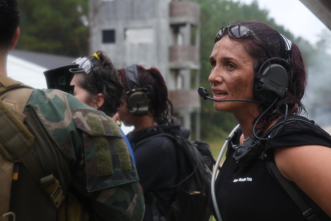 Participants of a Jane Wayne Day event raid a town during the last portion of a simulated special operations mission on Camp Lejeune, N.C., Oct. 19, 2013.  The event was organized by Marine Special Operations Regiment, allowing wives of MARSOC personnel to experience firsthand how Critical Skills Operators train for missions.  This Jane Wayne Day event immersed participants in an interactive scenario comprising patrols, a run through an obstacle course, rides on zodiac boats, encounters with role-players and a simulated raid on a town.  MARSOC Marines supervised the entire event, and assisted the family members throughout the scenario. (U.S. Marine Corps Photo by Lance Cpl. Steven Fox/Released)