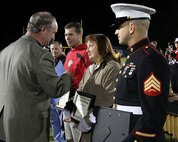 Jacksonville Mayor Sammy Phillips (left) speaks with a first responder who aided Sgt. Ty M. Baker Jr. (right) save a local man’s life at a high school football game during an award ceremony for the first responders in Jacksonville, N.C., Oct. 25, 2013. Baker and the two people who helped save Wayne Allen’s life were awarded certificates of accommodation from the city of Jacksonville and Onslow County, as well as a plaque from the Jacksonville Senior High School Booster Club during a football game. Baker is an auto maintenance technician with 2nd Maintenance Bn., Combat Logistics Regiment 25, 2nd Marine Logistics Group aboard Camp Lejeune, N.C.. (U.S. Marine Corps photo by Lance Cpl. Shawn Valosin)